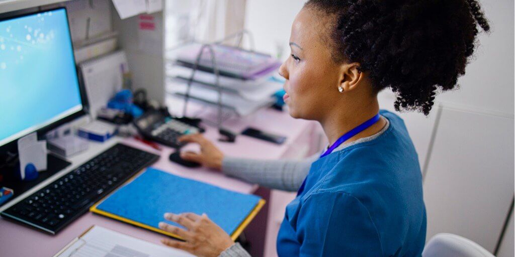 Nurse reviewing medical records at work station