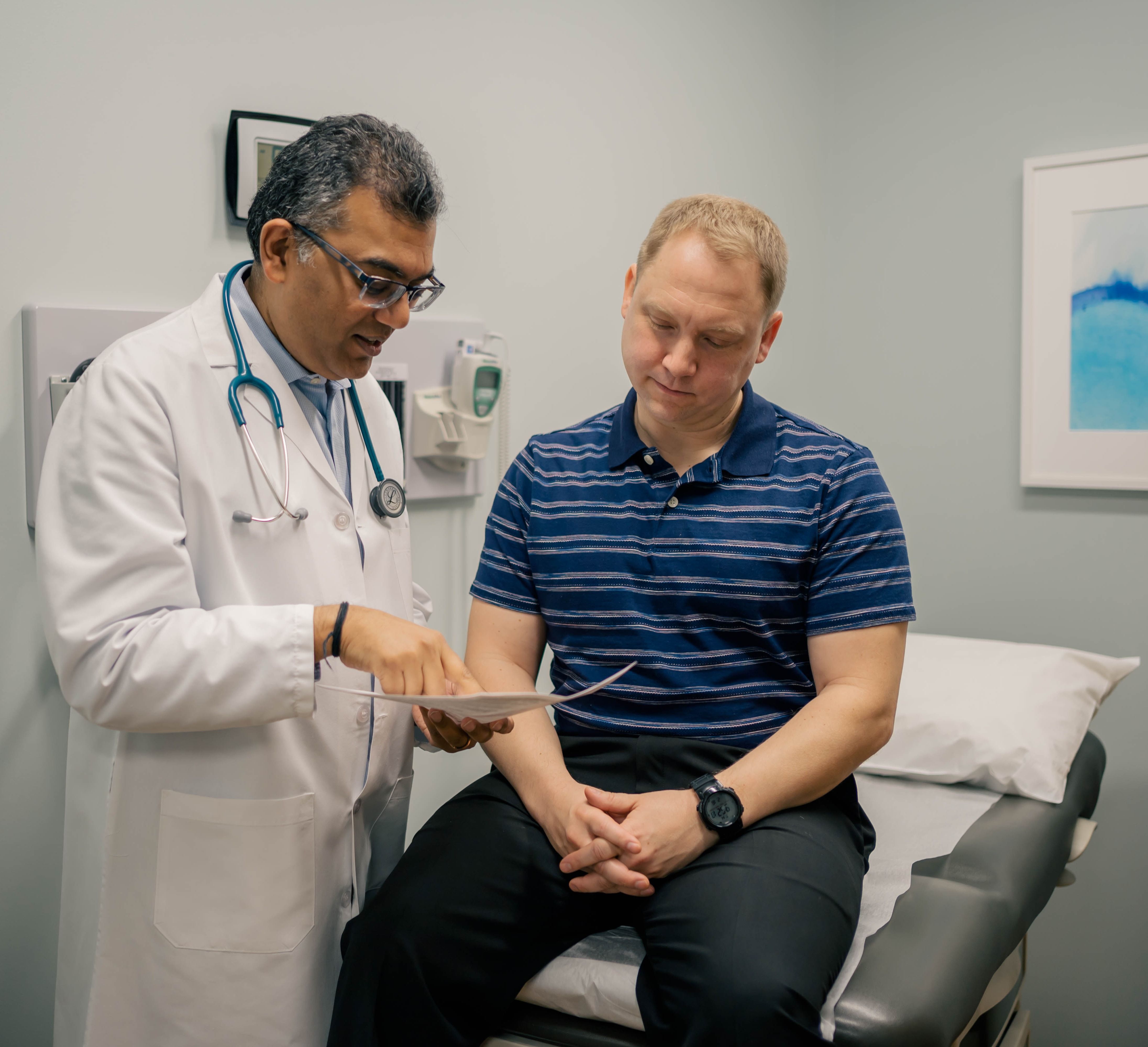 Dr. Rakesh Sarma, a concierge doctor in Sandy Springs, GA, reviews information with a patient during a visit