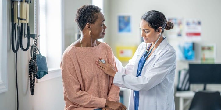 doctor listening to patient's heart/lungs