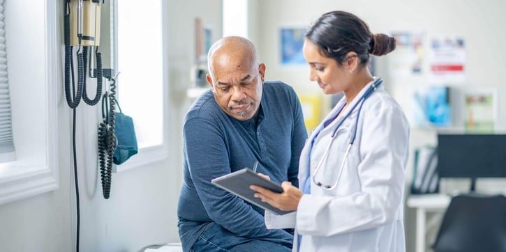 Doctor showing results to a patient on tablet. 