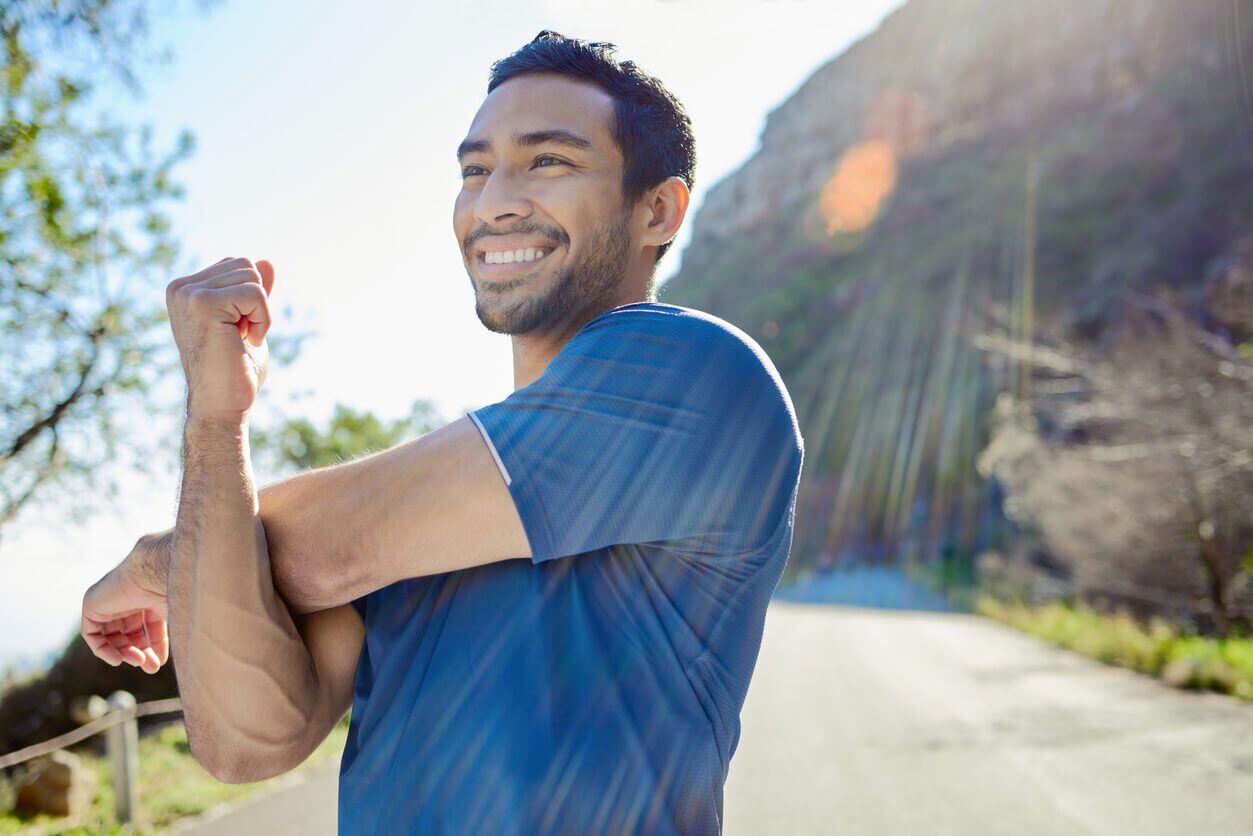 Man smiling while stretching. 