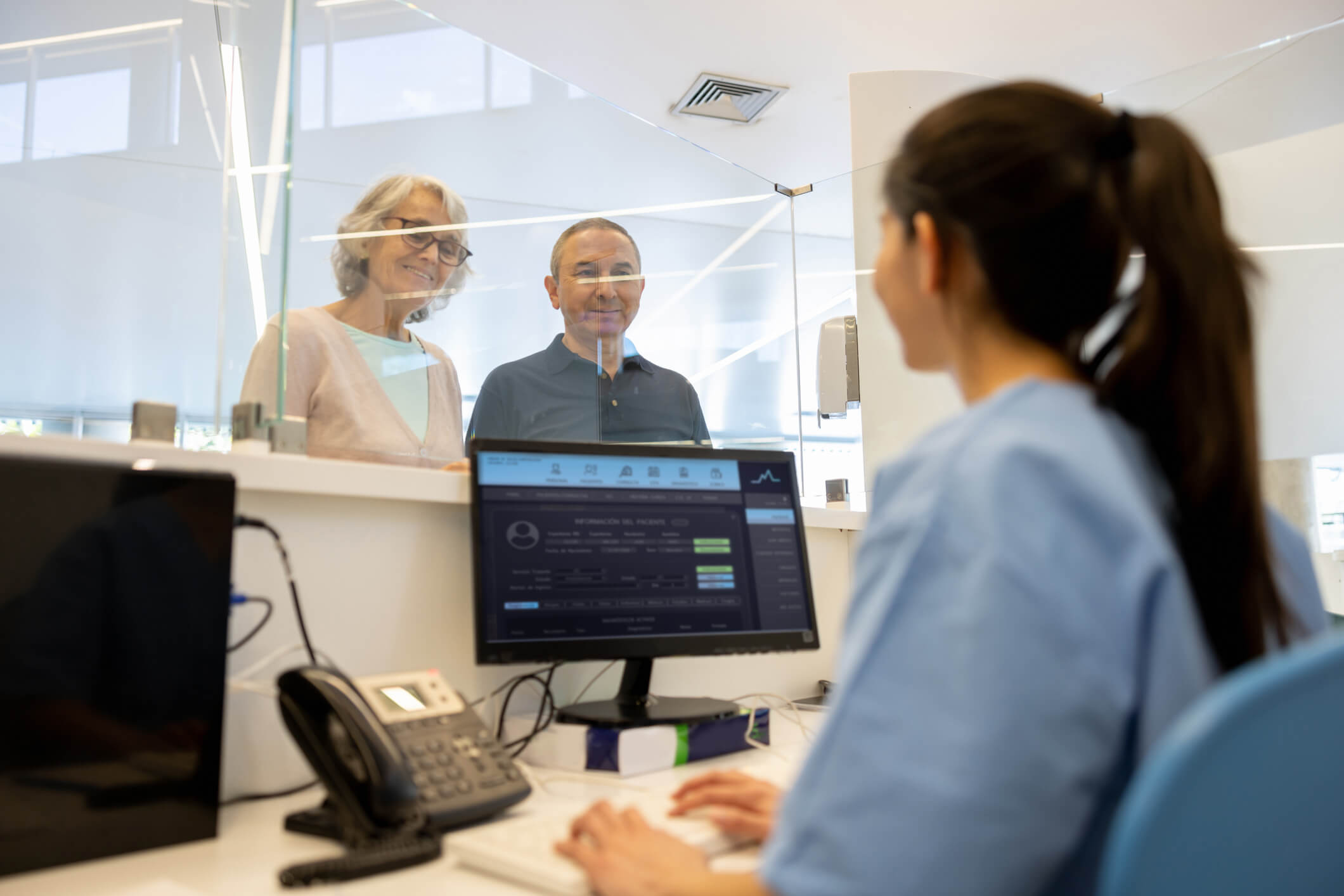 Two patients checking in for a doctor's appointment 